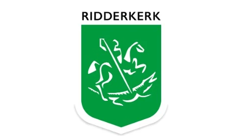 Groen schildvormig embleem met een wit abstract ridder- en paardenontwerp en het woord "RIDDERKERK" in vette zwarte letters erboven Groen schildvormig embleem met een wit abstract ridder- en paardenontwerp en het woord "RIDDERKERK" in vette zwarte letters erboven.